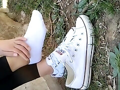 Chinese doll sprains foot in white ankle socks and dark-hued leggings