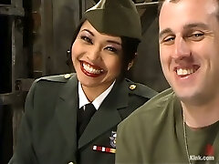 chica asiática en uniforme militar azota a un chica y se sienta en su cara