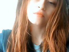 Red-haired Asian woman with tattoos blows smoke Red-haired Asian woman with tattoos blows smoke