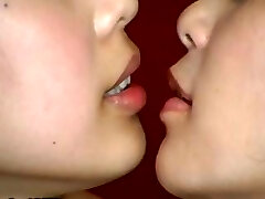 Two Japanese girls are doing some weird kissing with a jaws cork