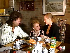 2 magnificent German chicks sharing a loaded cock on the kitchen table