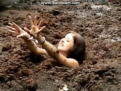 Manacled woman gets stuck in deep mud