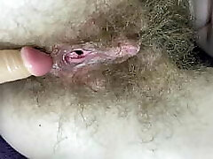 Hairy girl fucks her wet big joy button coochie with dildo in close up