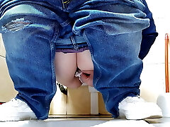 Hot MILF in jeans pissing in a public wc