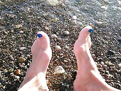 On public beach I sit on the shore wearing shorts and t-shirt and wetting my feet in the sea ...