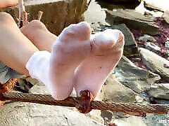 pies de xvideo dwl en calcetines blancos sucios primer plano contra la puesta de sol del mar
