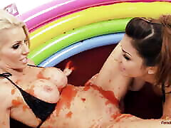 dwie seksowne lesbijki toczą się w błotnistym basenie i mają miękkie działania bdsm
