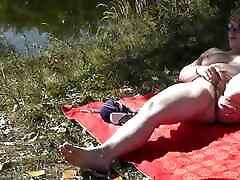 MILF solo. Wild beach. nilly caught fucking nudity. Sexy MILF on river bank fingers wet pussy and has strong orgasm. Naked in public. Outdoors