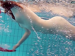 Red haired girl Libuse swimming in a pool in fire blank camera clip from bathrum dress