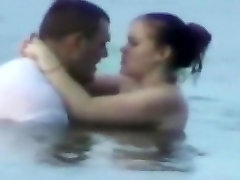 Voyeur tapes a horny couple having panty frotage in the sea
