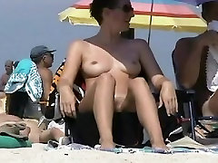 Big breasted coquette sunbathing on a nudist beach
