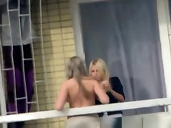 Voyeur films topless chick in the balcony