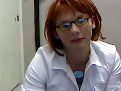 लाल बालों वाली जाल एक सफेद शर्ट पहने और चश्मा