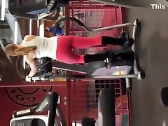 Tattooed blonde in red fitness couple workout pants exercising