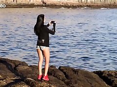 Pretty hot brunette Sapphira is flashing her tits on the rocky beach