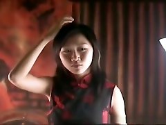 une jolie fille aux cheveux noirs dans une robe chinoise est attachée