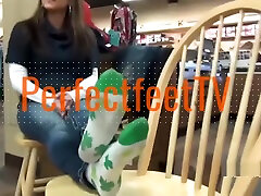 Teen girl takes off her socks to show her bare feet in public