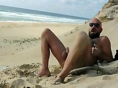 Bearded stud fucks himself on beach