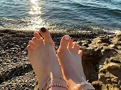 Mistress Lara plays with her feet and rap arund on the beach
