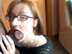 Red-haired milf in glasses sucks a small cock indoors