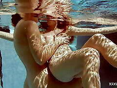 en la piscina cubierta, dos chicas impresionantes nadan