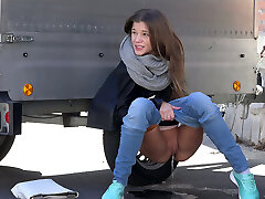 Lean young hottie hides behind the trailer and pisses