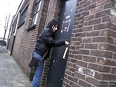 Blowing a cock through a glory hole after toying with her twat