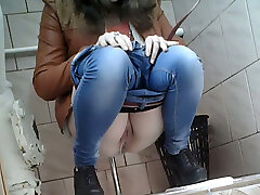 Slender girl in very tight blue jeans filmed in the toilet apartment
