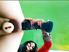 Bottom view, slave in chastity belt takes big toys into his hole.