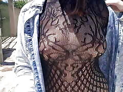 in a transparent outfit, she crossbows drivers in public in the city, her breasts are visible, her nipples are sticking out