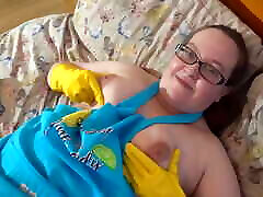 Mature in apron cleaning in rubber gloves