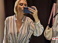 Seduction in a fitting room of a shopping mall. Trying on transparent clothes in a fitting room.