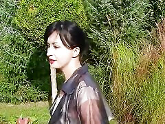 Garden, beautiful sunny day. Wanilianna in transparent raincoat, black seamed nylons