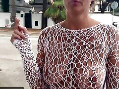 Alicia smokes a cigarette in a see-through dress in public