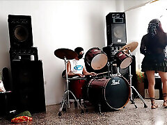 They play the drums for her - she dances, stripping and showing her ass