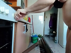 Sexy wife having fun in the kitchen with roses.
