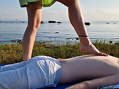 Foot massage by girl with long toes, long slim legs in skirt