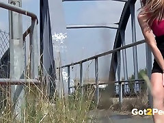 Sassy babe with slim long legs pisses on the metal bridge