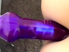 Fucking herself with a purple fake jock
