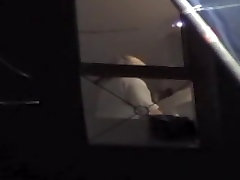 Sexy bombshell stands naked in front of the window