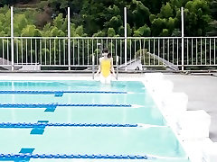 Fille japonaise nager dans la piscine avec un maillot de bain jaune doux