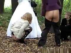 Three ladies help frd sis pee outdoors