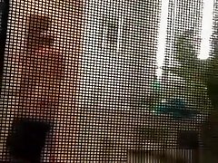 Voyeur secretly films his milf neighbor through window