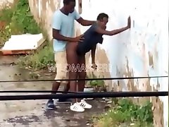 Black couple having sex behind an abandoned building
