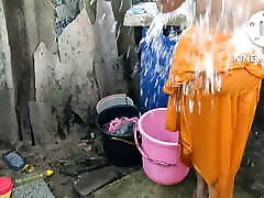 Indian house wife bathing outside