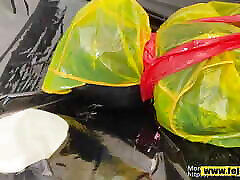 Fejira com Dressed in a yellow plastic raincoat tied with tape